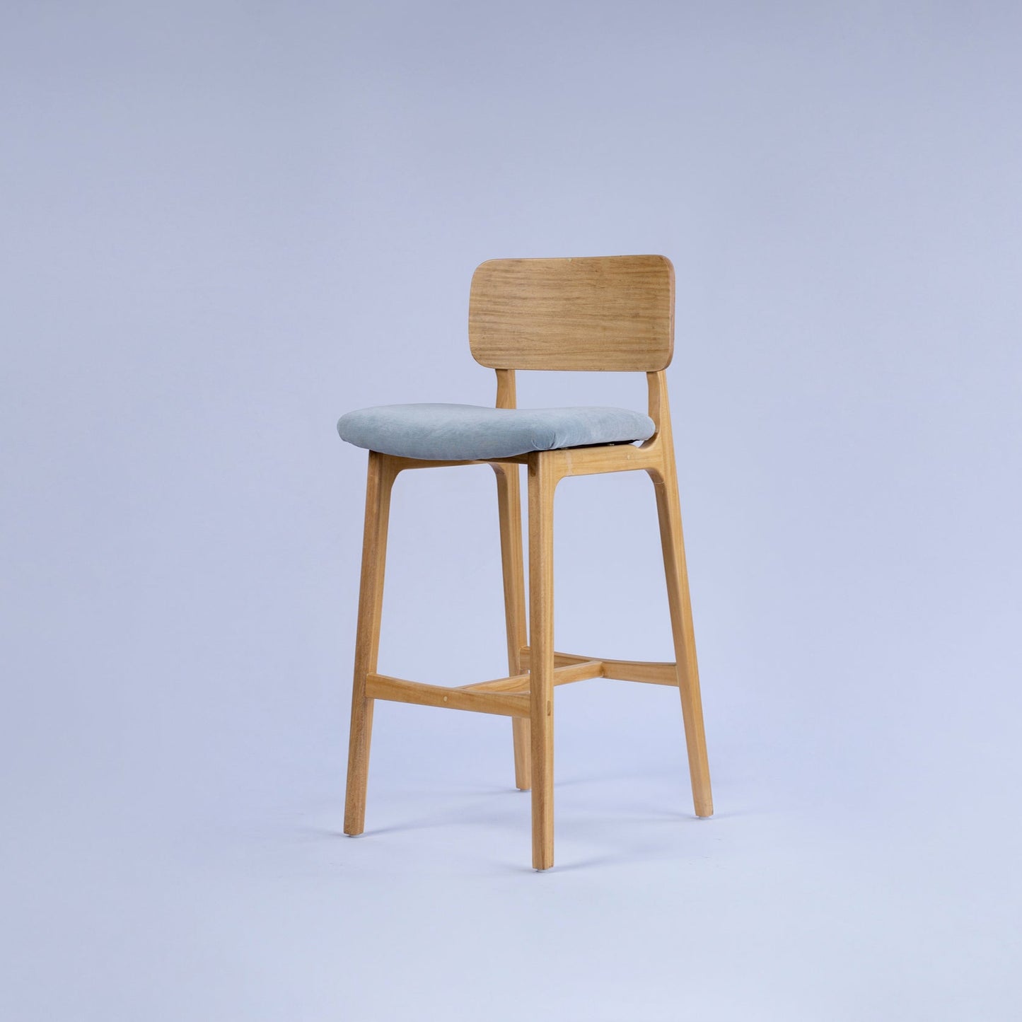Wooden bar stool with a gray seat on a light purple background